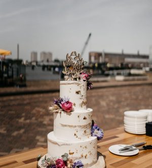 Semi naked cake on tree trunk with flowers