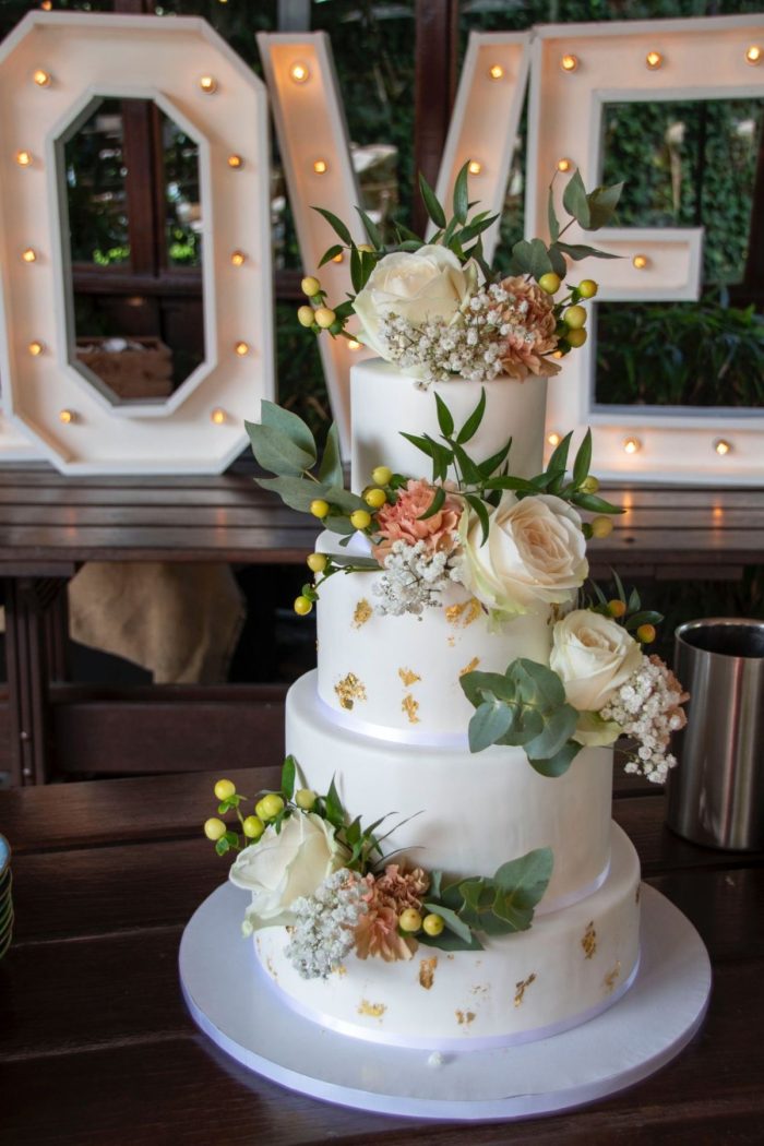 Witte fondant bruidstaart met bladgoud en klassieke verse bloemen