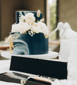 Blauwe marmeren bruidstaart met witte bloemen