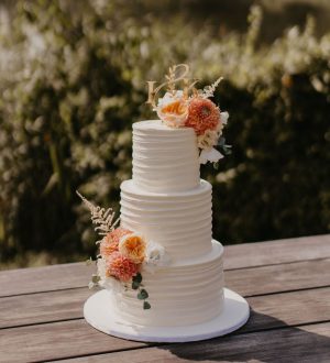 Creme strepen bruidstaart met peach bloemen