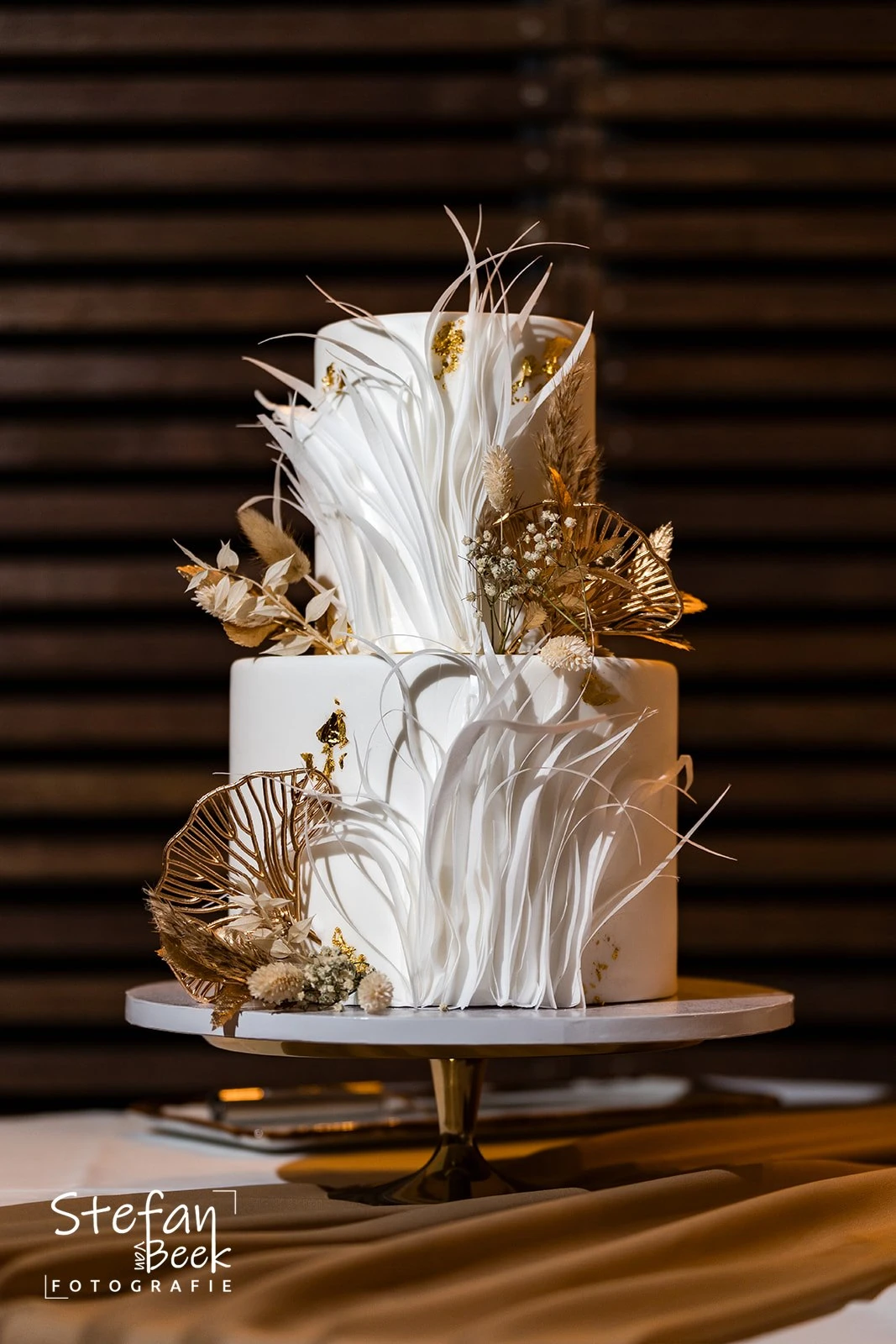 Moderne bruidstaart met 3D design, goudaccenten en droogbloemen