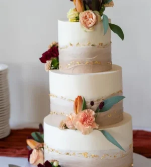 Elegante bruidstaart met verse bloemen, nude tinten en goudaccenten Elegante bruidstaart met verse bloemen, nude tinten en goudaccenten