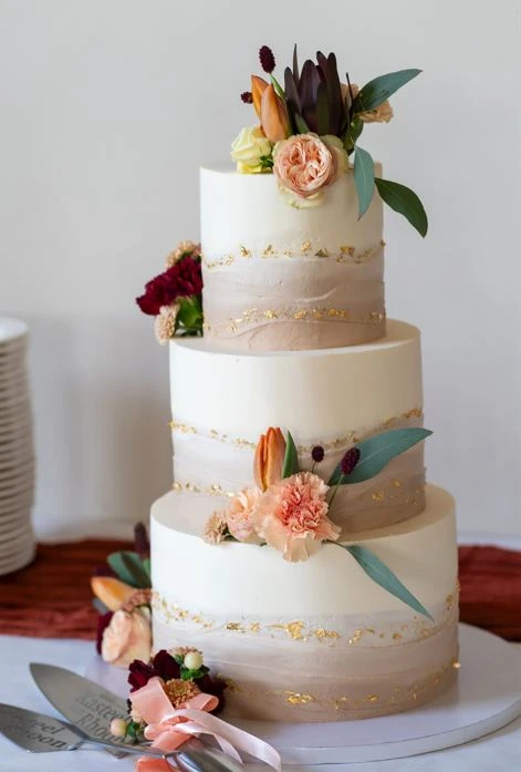 Elegante bruidstaart met verse bloemen, nude tinten en goudaccenten Elegante bruidstaart met verse bloemen, nude tinten en goudaccenten